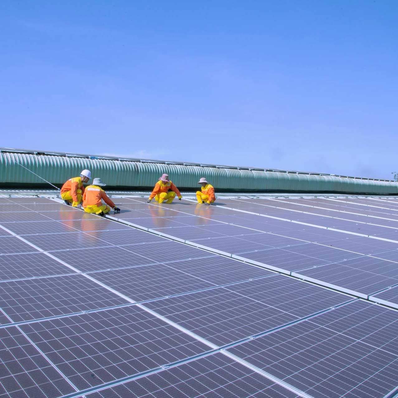 Tres operarios trabajando en una planta de energía solar